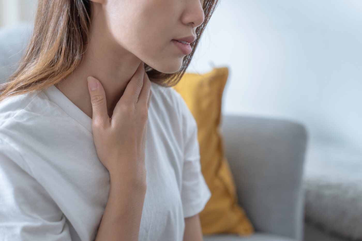 Woman touching the front of her neck